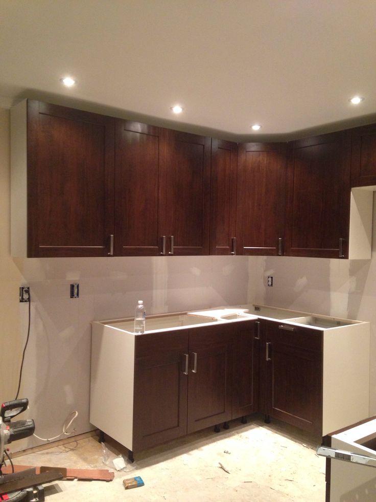 an unfinished kitchen with wooden cabinets and white counter tops in the process of remodeling