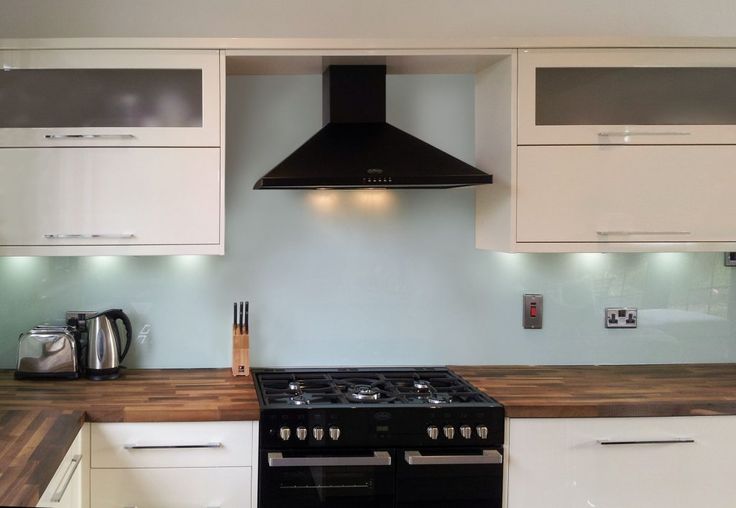 a stove top oven sitting inside of a kitchen next to white cabinets and counter tops