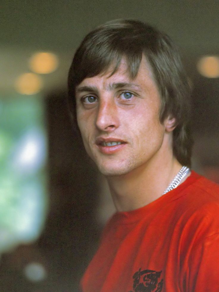 a young man in a red shirt posing for a photo