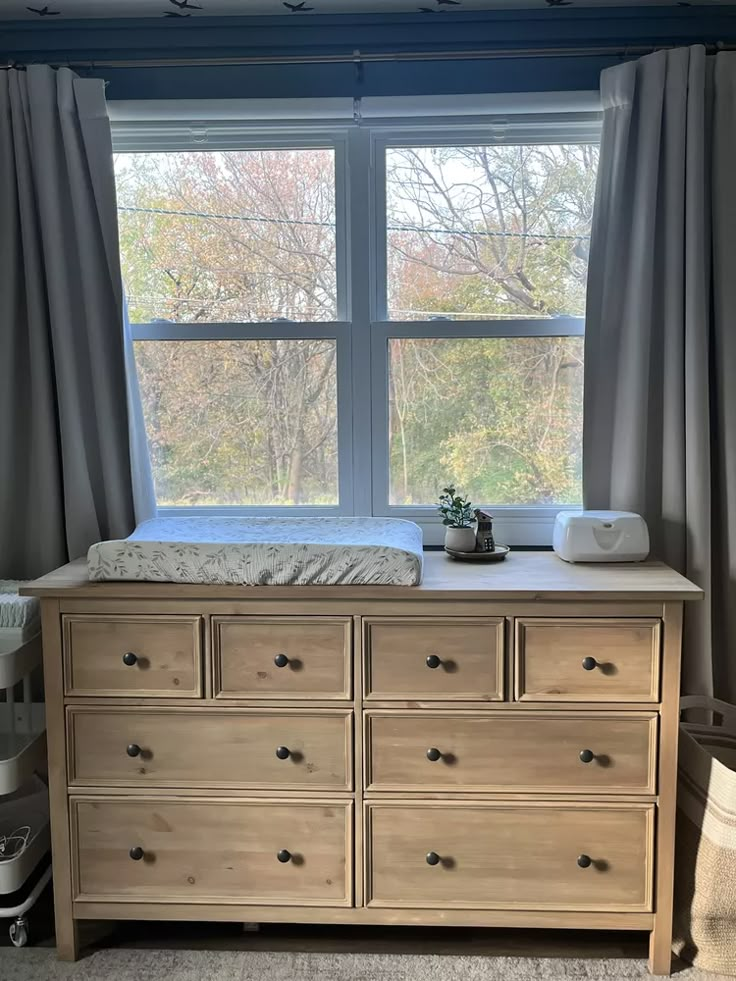 a dresser in front of a large window