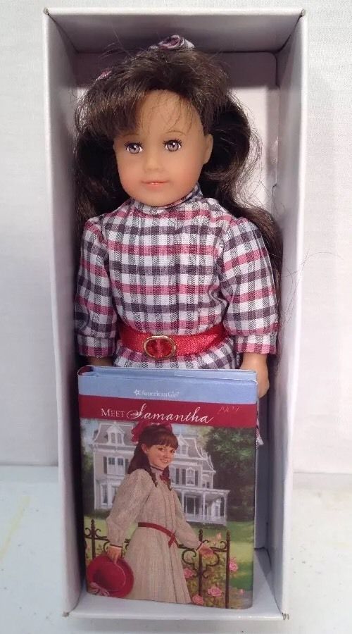 a doll in a box with a book on the front and back of it's head