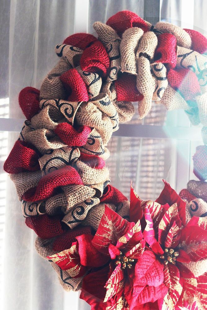 a burlock wreath with red bows hanging from the front door, on a window sill