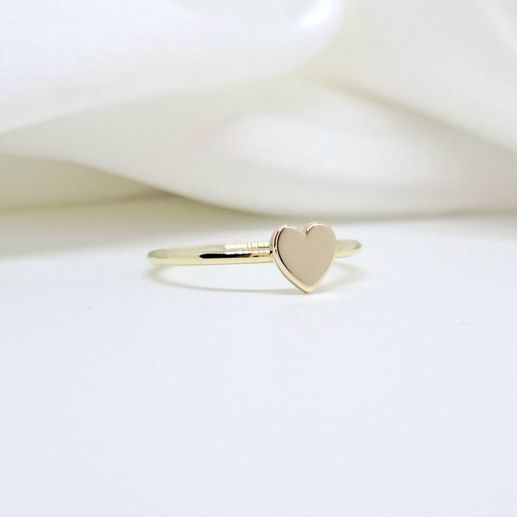 An all-gold and shiny heart will adorn your hand  🤍🤍 🤍 Details  The heart's size is 5,7mm. x  5,8mm. (approx.) and  thickness of heart is 1,00mm.(approx.) The band's thickness is 1,30mm.(approx.)  flat on the inside and slightly curved on the outside. 🤍 Materials All our items are made of 9 karats, 14 karats, or 18 karats solid gold upon request. We like to use yellow gold, white gold, and rose gold to please your color of choice. Use the drop-down material menu to find your favorite option. Gold 14k Heart-shaped Stackable Rings, Gold Heart-shaped Stackable Rings, Gold Heart-shaped Midi Rings In 14k Gold, 14k Gold Heart Shaped Stackable Rings, Gold Heart-shaped Stackable Rings For Valentine's Day, 14k Gold Rings With Heart Charm And Heart Cut, 14k Gold Stackable Rings With Heart Charm, Yellow Gold Heart Charm Promise Ring, Gold Heart-shaped Midi Rings With Heart Charm