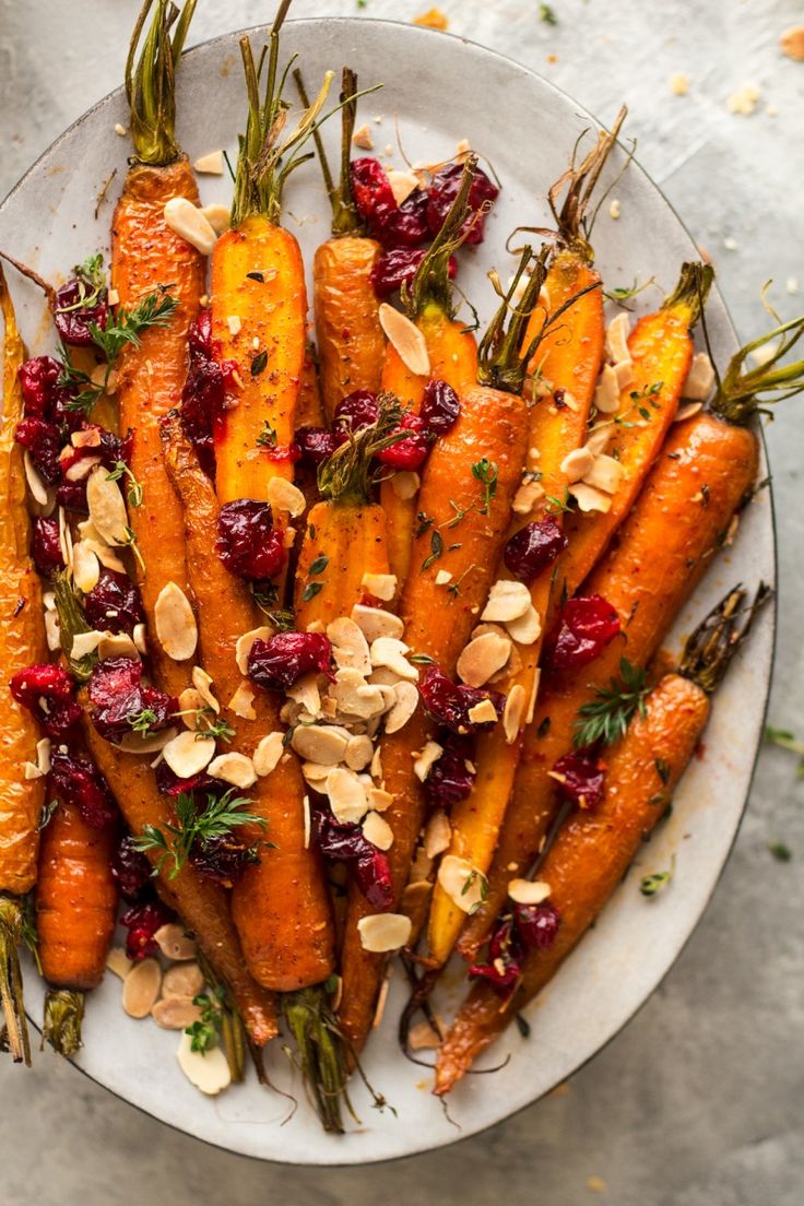 roasted carrots with cranberry sauce and almonds on a white platter