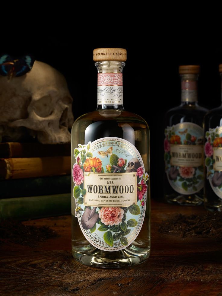 three bottles of wormwood are sitting on a table next to a human skull