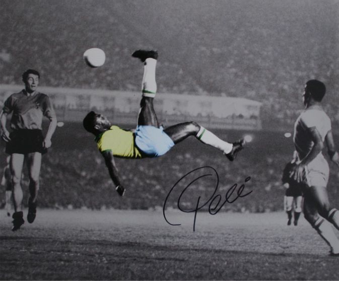 an autographed photograph of a soccer player jumping in the air to catch a ball