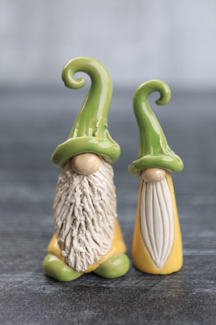 two green and white gnome figurines sitting next to each other