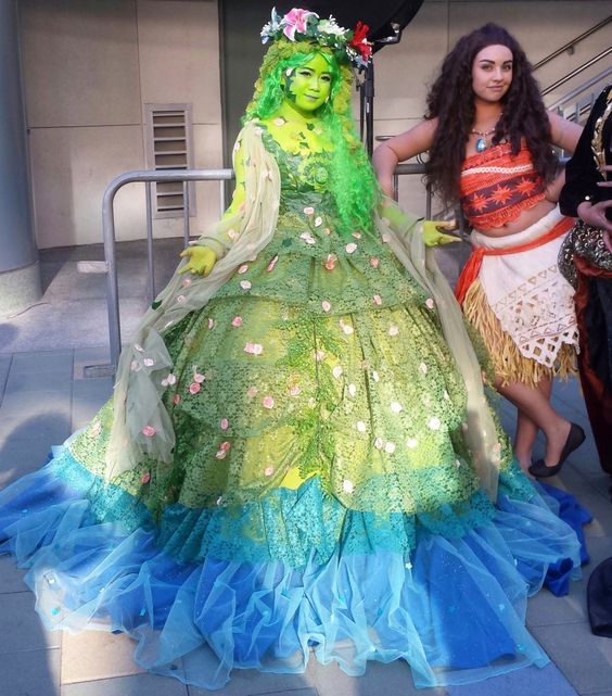 two women standing next to each other in costumes