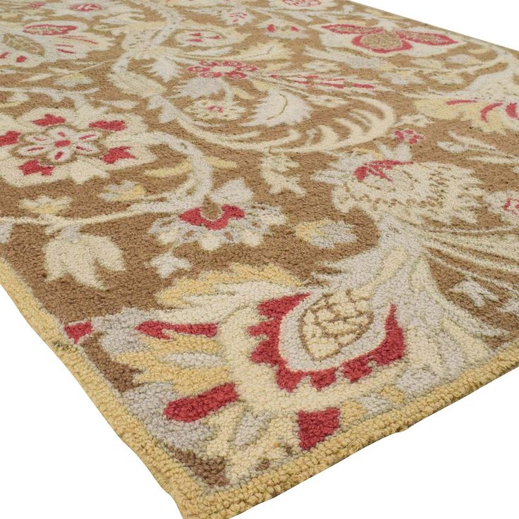 a brown and red rug with an ornate design on the bottom, in front of a white background