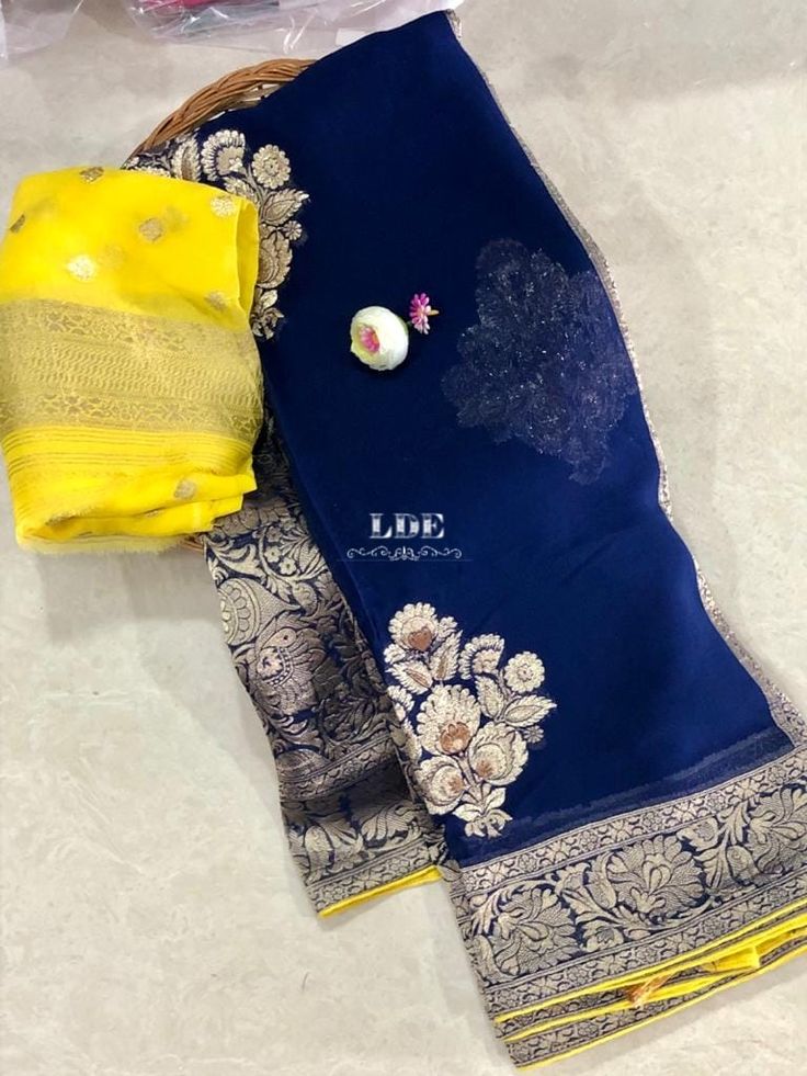 blue and yellow saree laying on top of a white floor next to a basket