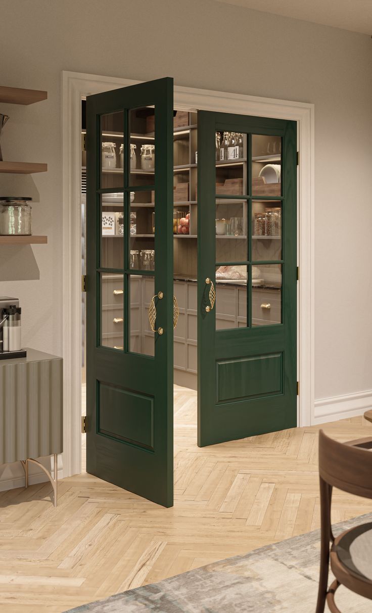 two green doors are open in the middle of a room with wooden floors and shelves