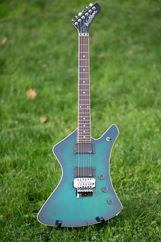 a blue guitar sitting on top of a lush green field