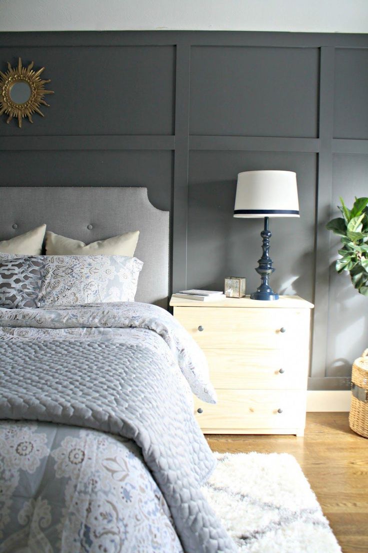 a bedroom with gray walls and white bedding