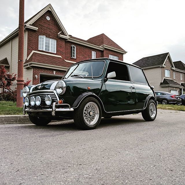 an old black car parked in front of a house