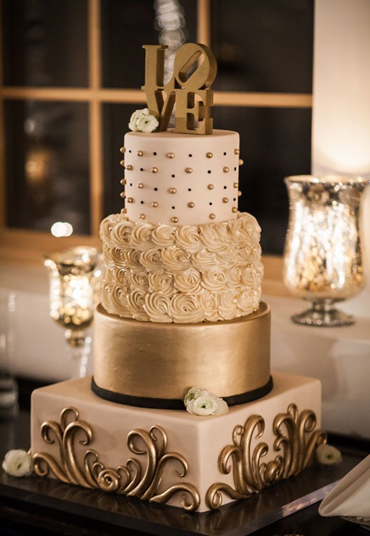 a three tiered cake sitting on top of a table next to a candle holder