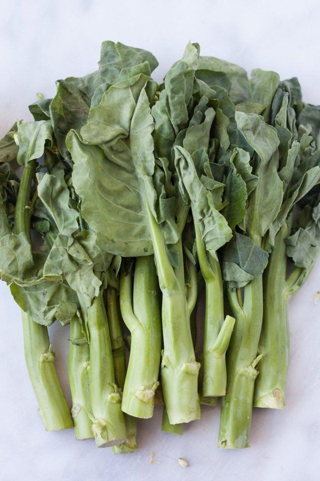 some green vegetables are laying on a white surface