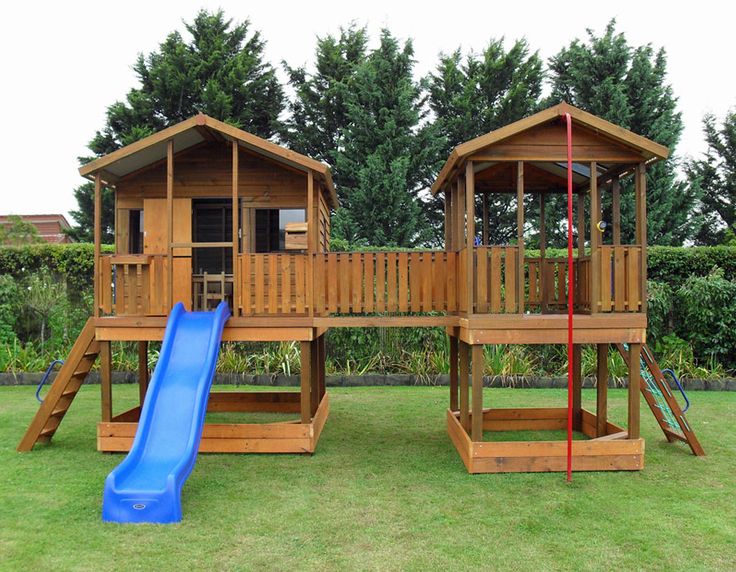 two wooden play structures with a blue slide