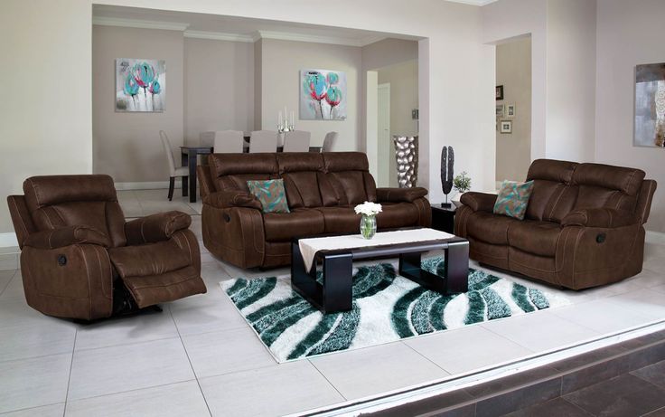 a living room filled with brown furniture and a white rug on top of a hard wood floor