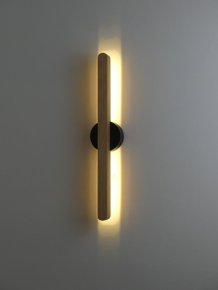 a light that is on the wall next to a white wall with a black handle