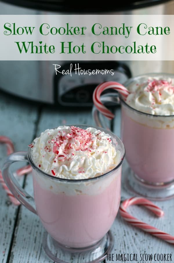 two mugs filled with candy cane white hot chocolate on top of a wooden table