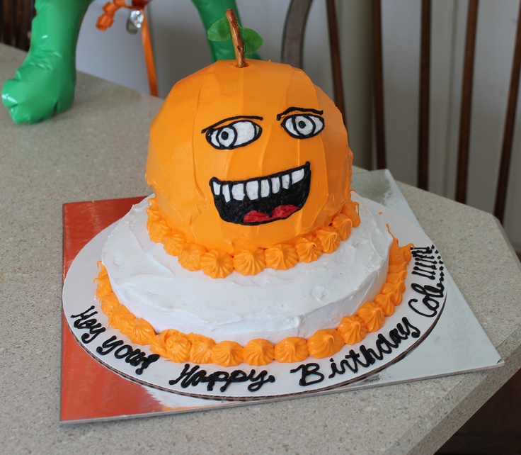 a birthday cake with an orange pumpkin on top