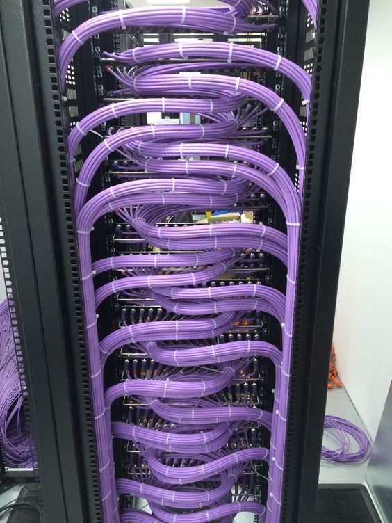 the purple cables are connected to each other in the server's rack, which is filled with many different types of wires