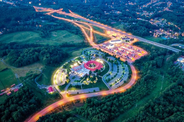 an aerial view of a city at night with lights on the buildings and roads in the foreground