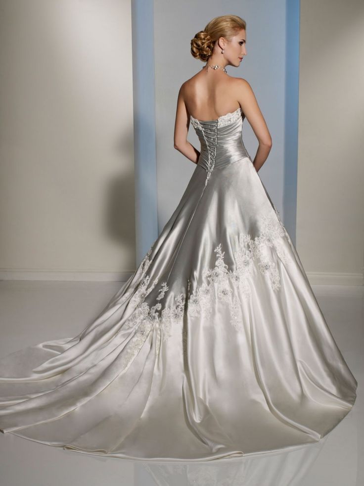 a woman in a wedding dress is standing against a blue and white striped wall with her back turned to the camera