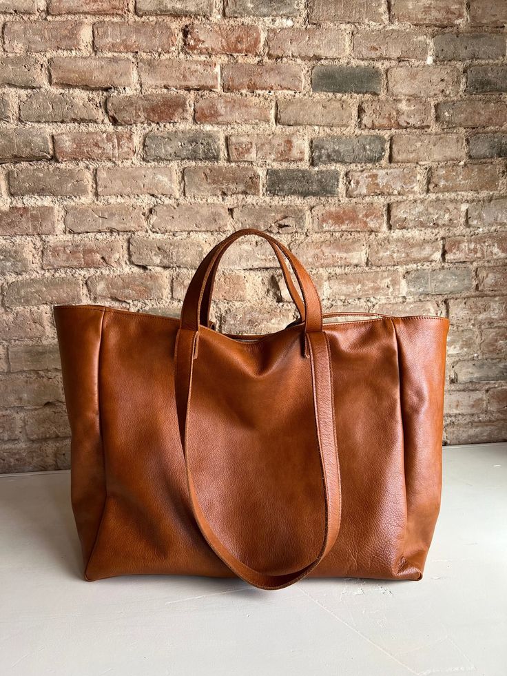 Beautiful oversized leather bag, with double handles, and a big capacity to carry many things for your day, or for your weekend! This bag is made with a buttery soft full grain leather, that adapts very nicely to what you need to carry. It's a big bag, but if you don't fill it, it folds beautifully and it's not bulky. Size: width at top: 57 cm width at bottom: 40 cm Depth: 22 cm Height: 31 cm Short handles: Drop of 11 cm Longer handles: drop of 30 cm This bag is fully lined and it has 3 open poc Soft Leather Tote Travel Bag For On-the-go, Large Capacity Duffle Bag With Double Handle For Shopping, Large Capacity Top Handle Travel Bag For Everyday, Everyday Large Capacity Top Handle Travel Bag, Large Capacity Weekender Bag With Double Handle, Top Handle Weekender Bag With Large Capacity For Shopping, Everyday Large Capacity Satchel Duffle Bag, Brown Travel Bag With Large Capacity And Double Handle, Shopping Weekender Bag With Top Handle And Large Capacity