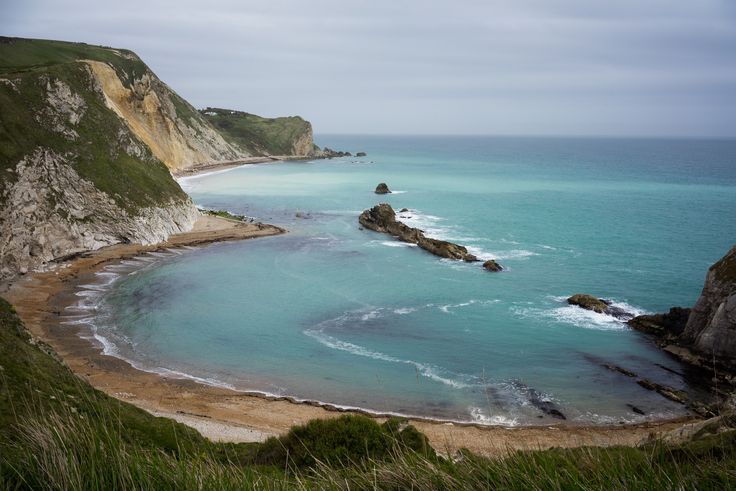 the ocean is blue and green with white cliffs