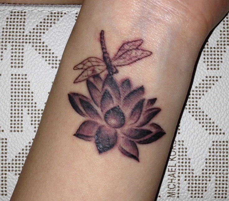 a woman's arm with a dragonfly on it and a flower tattoo design