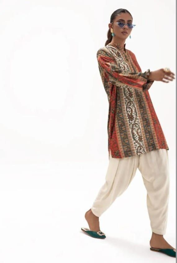 Introducing our stunning and chic two-piece kurta and pants set - a must-have addition to your wardrobe. Made from high-quality fabric, this set is designed for both comfort and style. The kurta features delicate details that add a touch of elegance to your look. The length of the kurta is just right, hitting just above the knees for a modern and sophisticated look.  The pants are designed in a straight leg style, featuring a comfortable and adjustable waistband for a perfect fit. The length is just right to complement the kurta, creating a cohesive and stylish outfit. Whether you're attending a wedding, Eid celebration, or simply want to elevate your everyday look, this set is perfect for any occasion. Pair it with your favorite accessories, shoes, and bag to create a complete look that w Bollywood Pant Set With Traditional Drape For Navratri, Bollywood Style Palazzo Set With Dupatta And Tunic, Bohemian Designer Palazzo Set For Eid, Eid Festive Tunic Palazzo Set, Designer Palazzo Set With Tunic For Eid, Eid Dabka Palazzo Set With Tunic, Bohemian Palazzo Set For Eid Designer Wear, Festive Eid Palazzo Set With Tunic, Festive Eid Tunic Palazzo Set