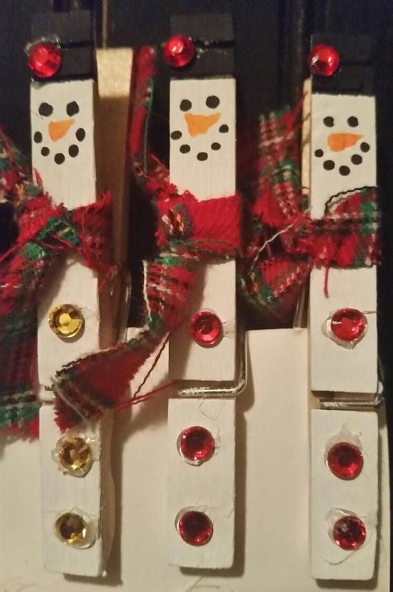 four snowmen made out of dominos with red and green bows on them, sitting next to each other