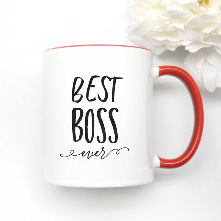 a red and white coffee mug with the words best boss ever on it next to a flower