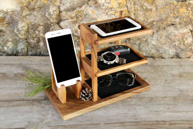 a wooden stand with two cell phones on top of it and an iphone in the middle