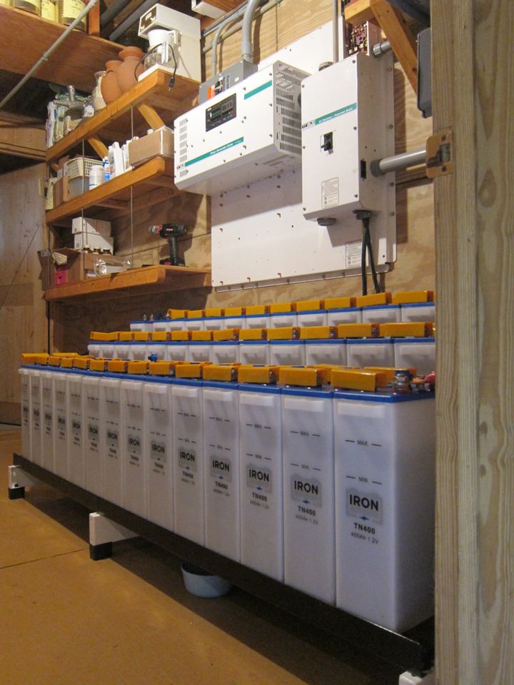 several batteries are stacked on top of each other in a storage room with wooden shelves