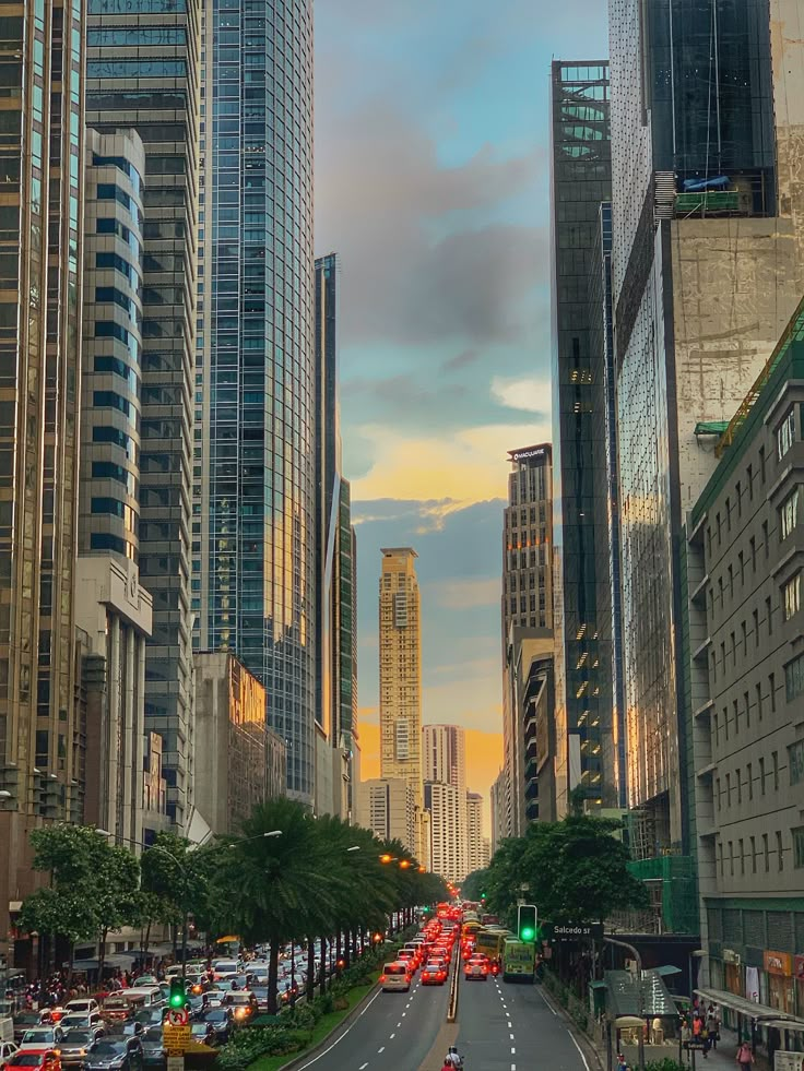 a city street filled with lots of traffic next to tall buildings in the evening sun