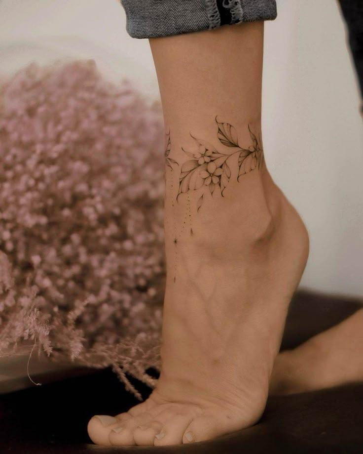 a woman's foot with a flower tattoo on it