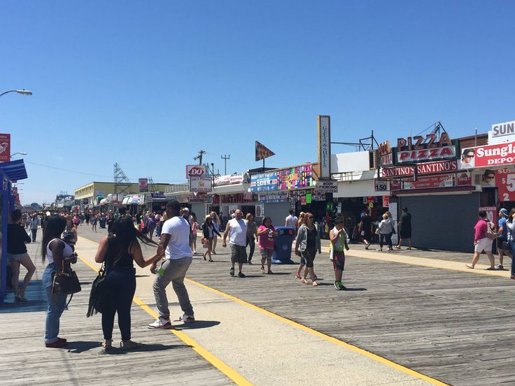 many people are walking around on the boardwalk