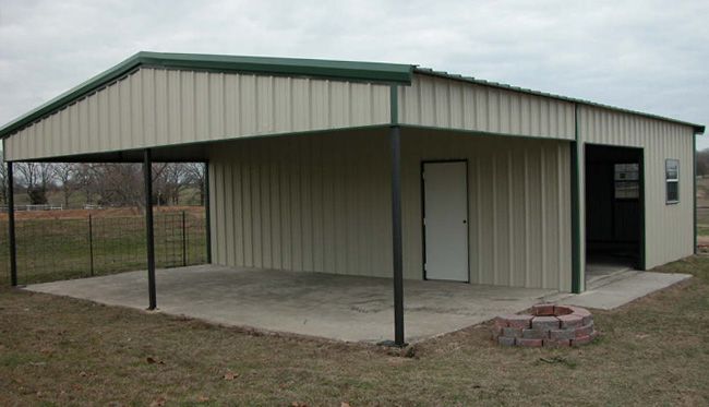 a metal building with an open door on the front and side of it in a field