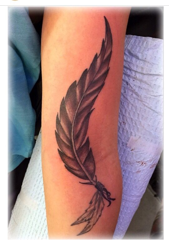 a tattoo with a feather on the arm