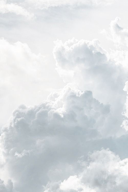 an airplane is flying through the cloudy sky