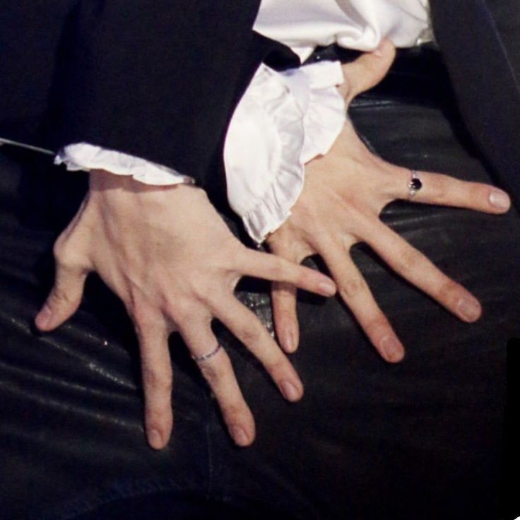 a man in a tuxedo with his hands on his lap