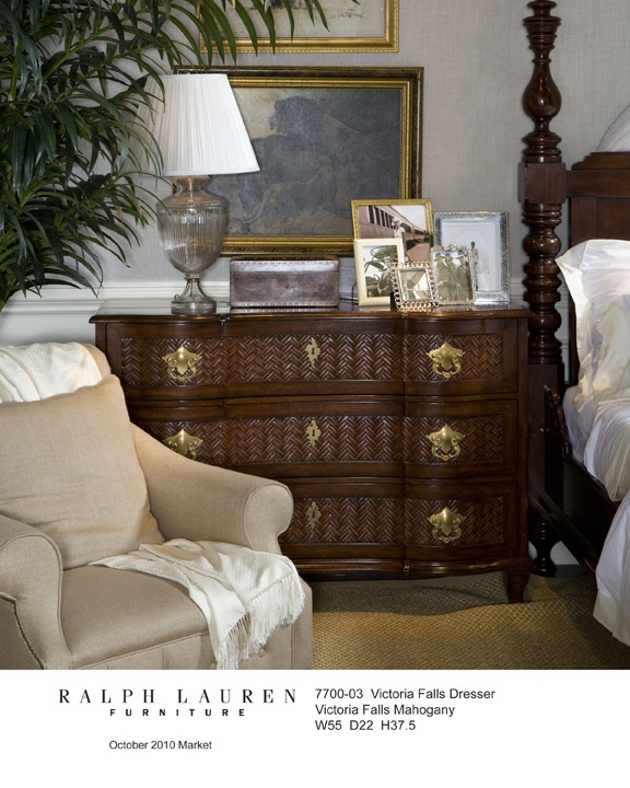 a bed room with a neatly made bed and a wooden dresser next to a chair