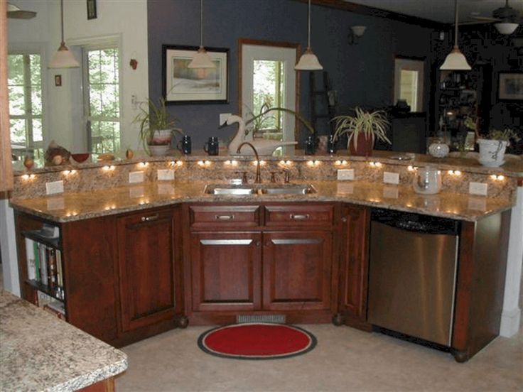 a kitchen with granite counter tops and wooden cabinets is lit by candles on the counters