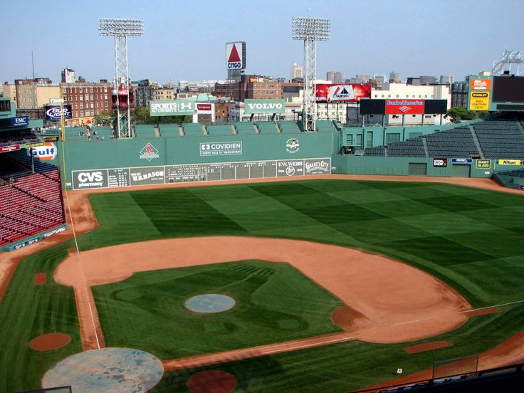 an empty baseball field in front of a stadium full of fans and players on the sidelines