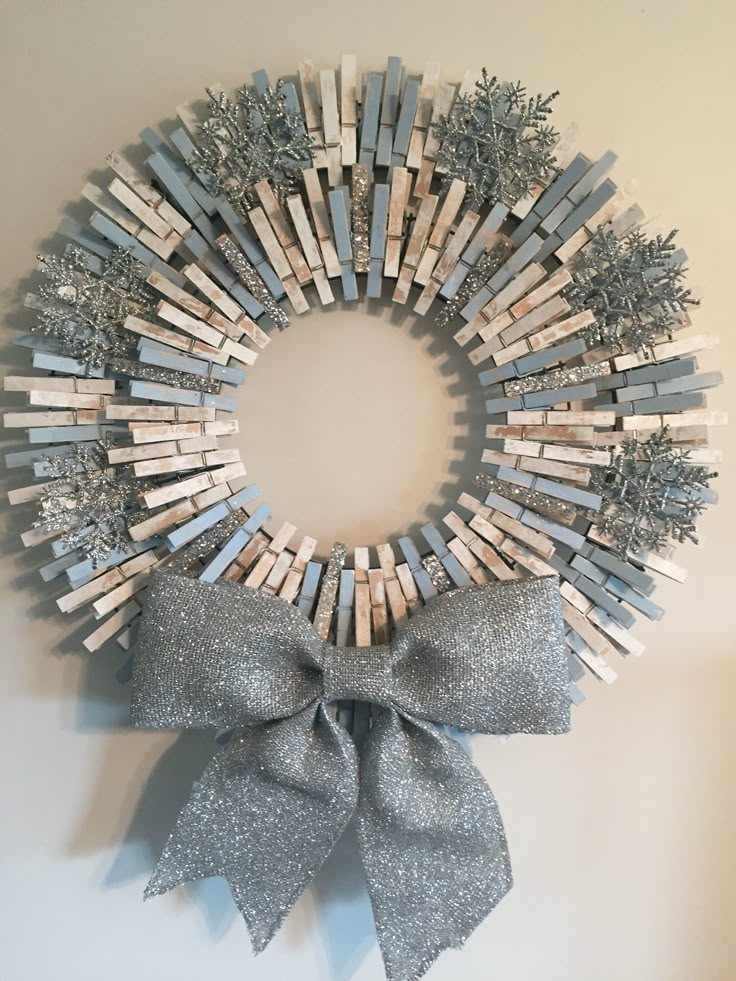 a wreath made out of clothes pins with a bow hanging on the front of it