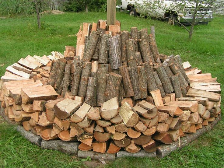 a pile of wood sitting on top of a lush green field