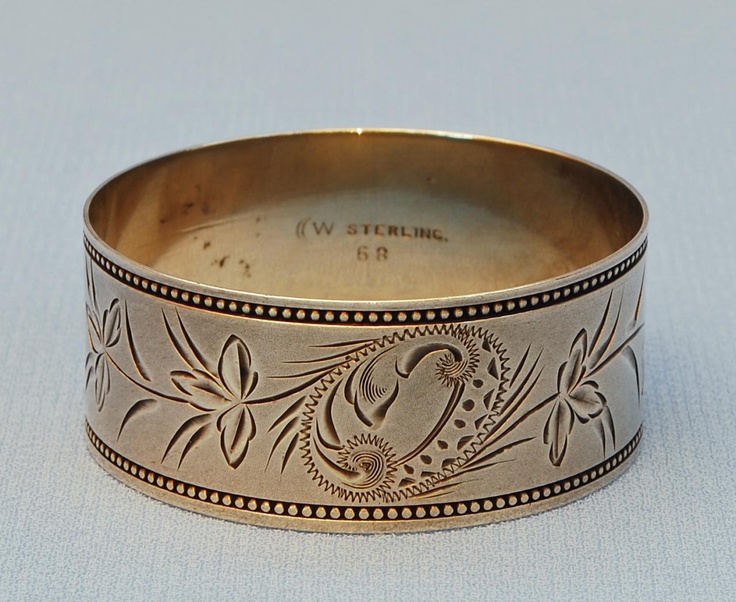 an old silver bracelet with floral designs on it