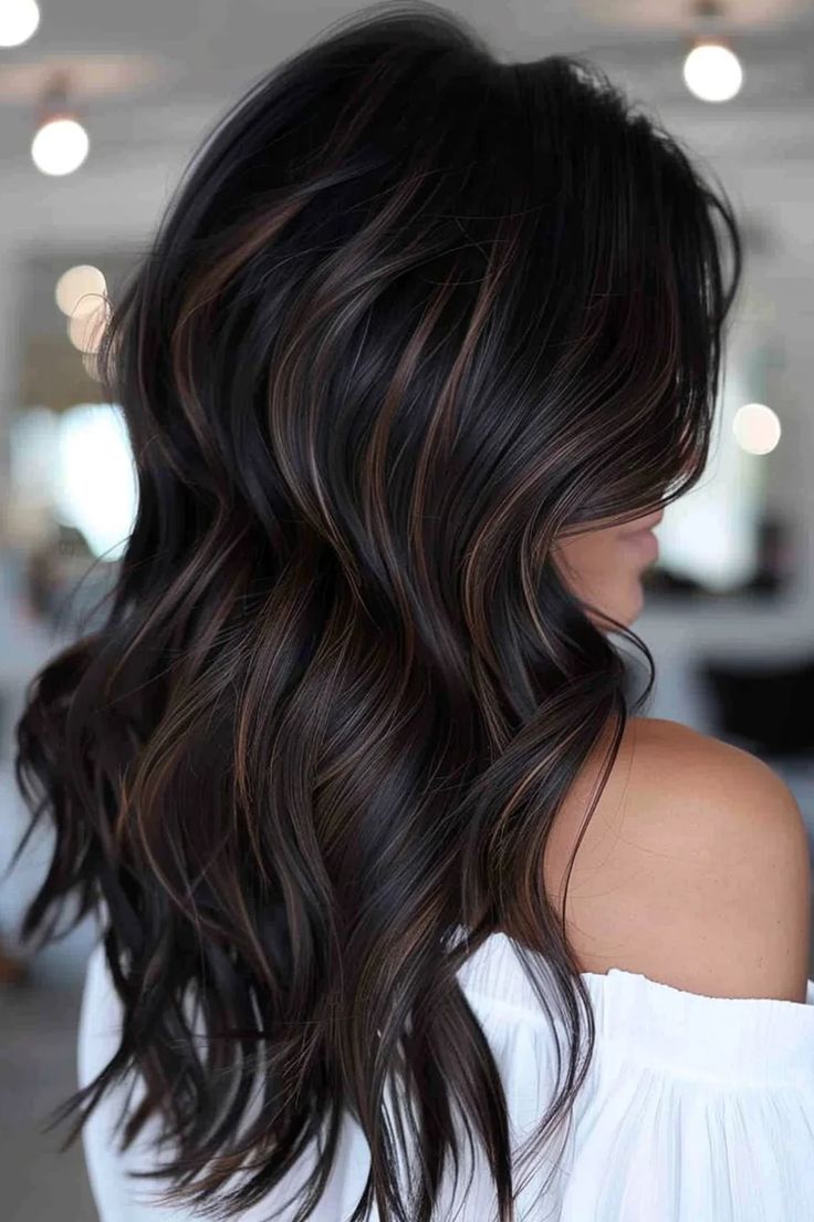 Woman with long, wavy dark hair featuring subtle highlights, wearing an off-shoulder white top. Hair Balayage For Black Hair, Black Dark Brown Balayage, Dark Hair With Black Lowlights, Dark Brown Black Balayage, Black Hair To Brunette, Simple Highlights For Black Hair, Dark Roast Hair, Black Hairstyles With Highlights, Dark Chocolate Brown Hair Highlights